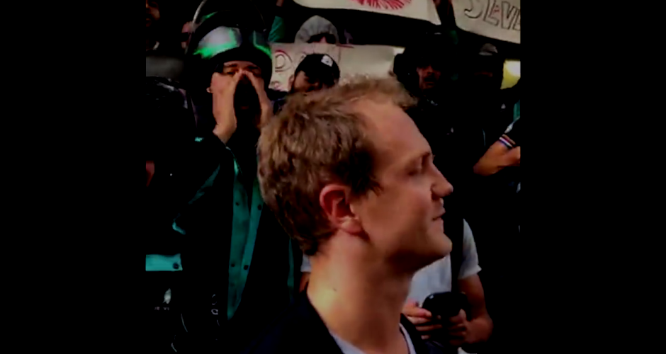 Deliveroo drivers surround Manager in front of company headquarters.